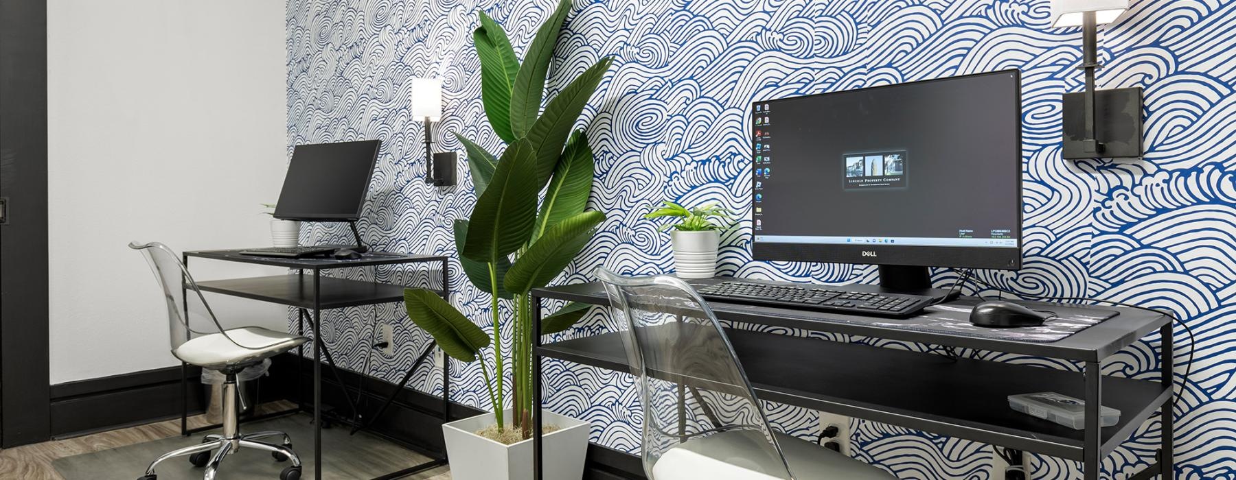 a desk with a computer and chairs